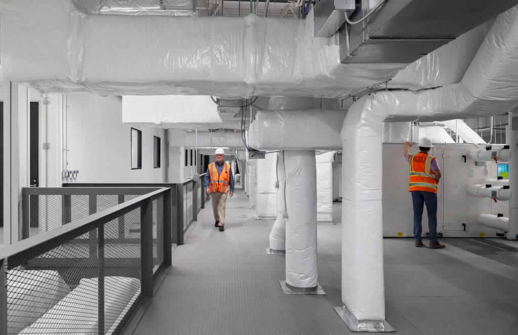 Technicians inspecting HVAC ducting and mechanical systems at Cellipont’s GMP manufacturing facility, ensuring optimal environmental control for cleanroom operations.