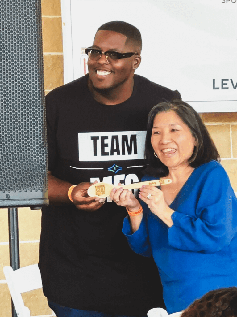 Cellipont Bioservices team members celebrating a cook-off win with a custom wooden spoon award, reflecting employee engagement and fun workplace events.