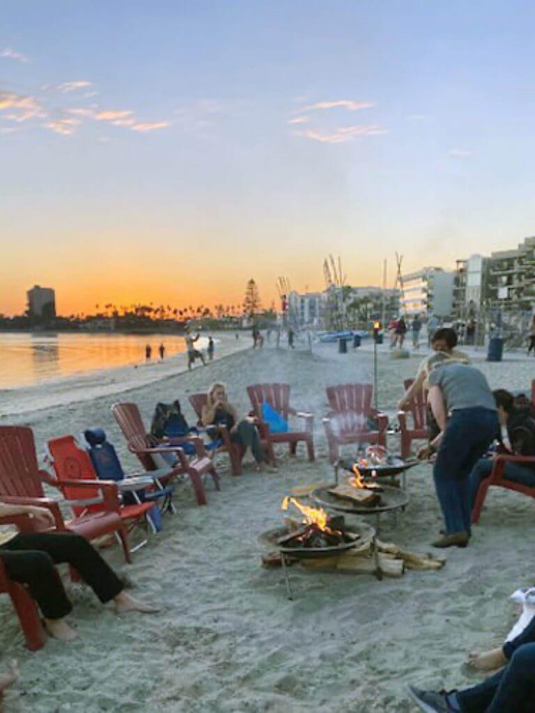 Cellipont team members enjoying a beach bonfire at sunset during a team-building event.